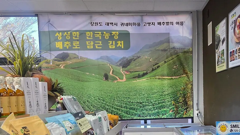 Store banner of a hillside Korean cabbage farm: “kimchi made with fresh Korean farm cabbage”