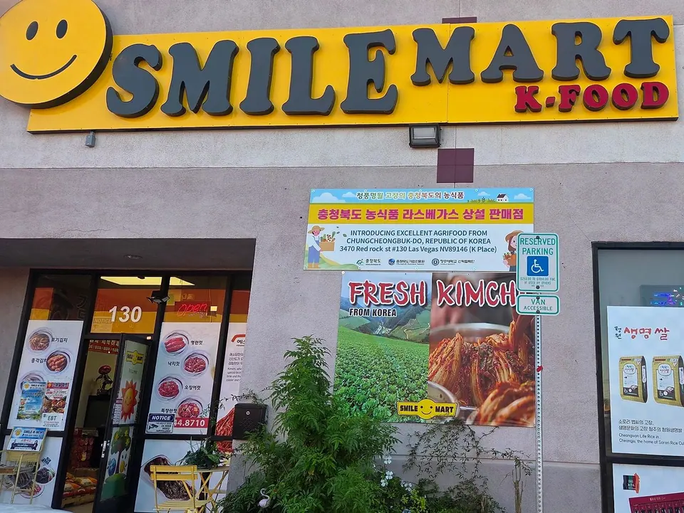 Smile Mart storefront: the yellow SMILE MART K-FOOD sign with its smiley, a Chungcheongbuk-do agrifood banner, a FRESH KIMCHI banner and entrance #130